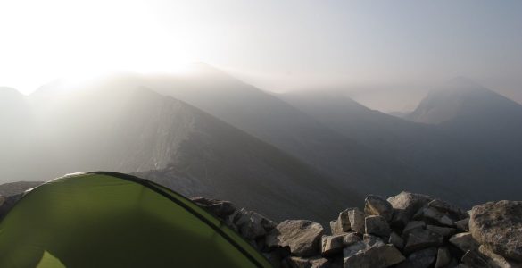 Tienda de campaña Vaude UL Hogan montada con fuerte viento en la Sierra de Pirin, detrás de un vivac, cerca de 3000 metros de altitud.
