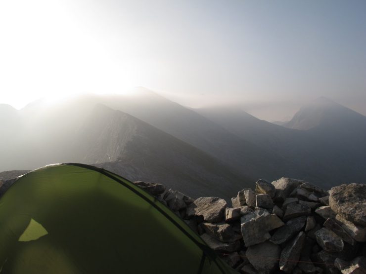Tienda de campaña Vaude UL Hogan montada con fuerte viento en la Sierra de Pirin, detrás de un vivac, cerca de 3000 metros de altitud.