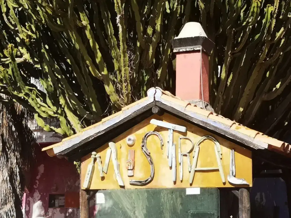 Techo y muro frontal de una casa en Albufeira con el nombre del viento Mistral rotulado, mostrando la relación entre el viento y la cultura local