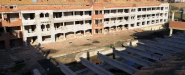 Foto a color de una propiedad en ruinas con muchas casas en abandono, faltan puertas, ventanas y todo cayendo a trozos. Creative Commons atribución 4.0 internacional