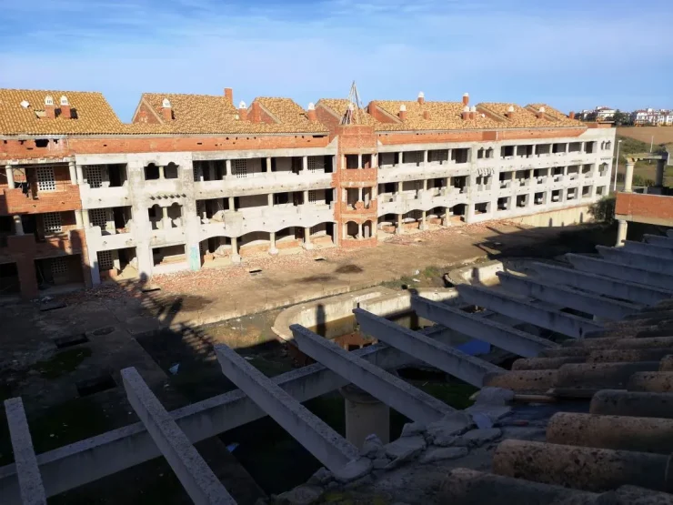 Foto a color de una propiedad en ruinas con muchas casas en abandono, faltan puertas, ventanas y todo cayendo a trozos. Creative Commons atribución 4.0 internacional