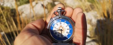 Foto en colores Mano sujetando un reloj para orientarse con el sol. Creative Commons atribución 4.0 internacional