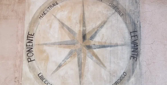 Rosa de los vientos de 8 puntas con nombres de los vientos en italiano dibujada en el muro de una casa en San Felice Circeo