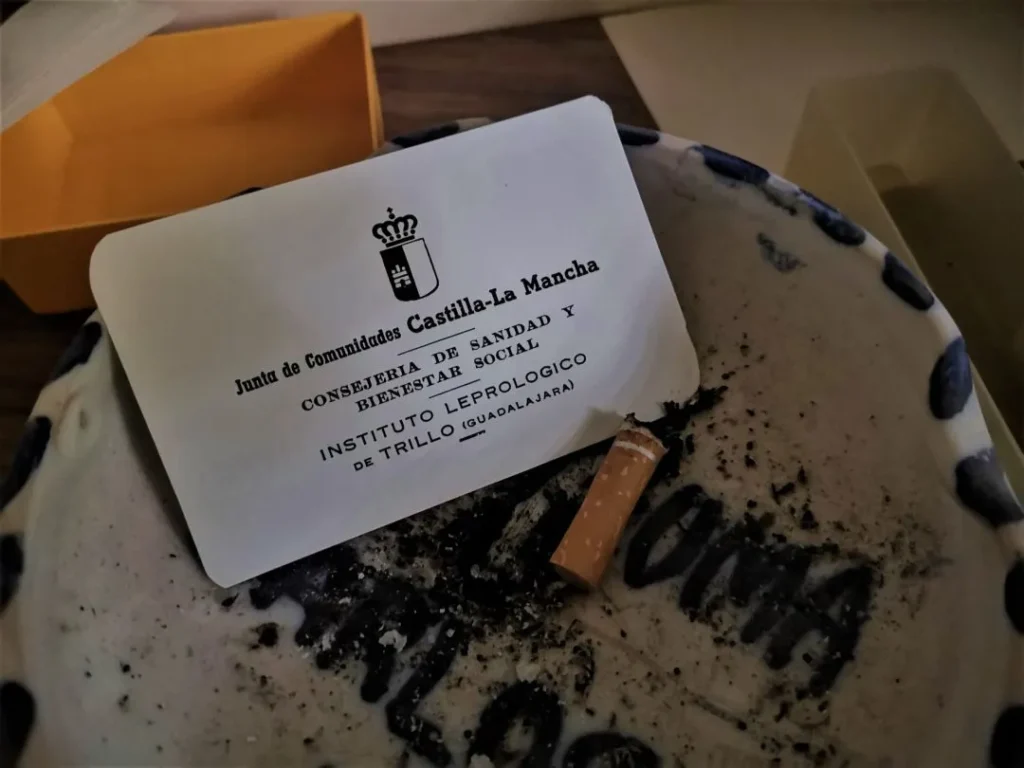 Cenicero con una colilla y una tarjeta de la Consejería Nacional en el Instituto Leprológico Nacional de Trillo, vestigios de su pasado
