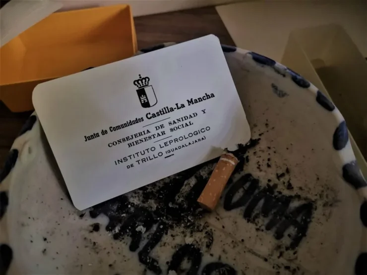 Cenicero con una colilla y una tarjeta de la Consejería Nacional en el Instituto Leprológico Nacional de Trillo, vestigios de su pasado