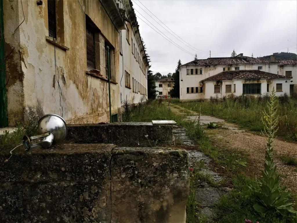 Edificios y patios llenos de maleza en la Leprosería de Trillo, mostrando el abandono de este lugar histórico. Autor: Viaje a Edén