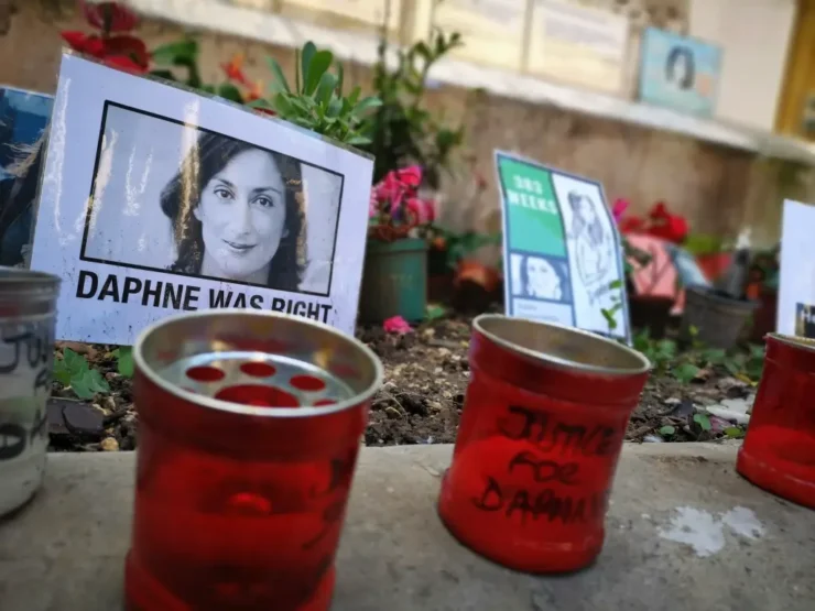 Velas, fotos y pancarta en los pies de una estatua en la Plaza The Great Siege, Malta, pidiendo justicia por el asesinato de la periodista Daphne Caruana Galizia