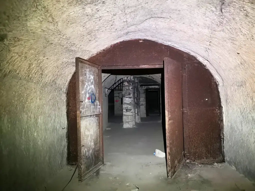 Gran cancela de hierro en los subterráneos del Palacio Viejo del Lazareto de Malta, con sala abovedada al fondo