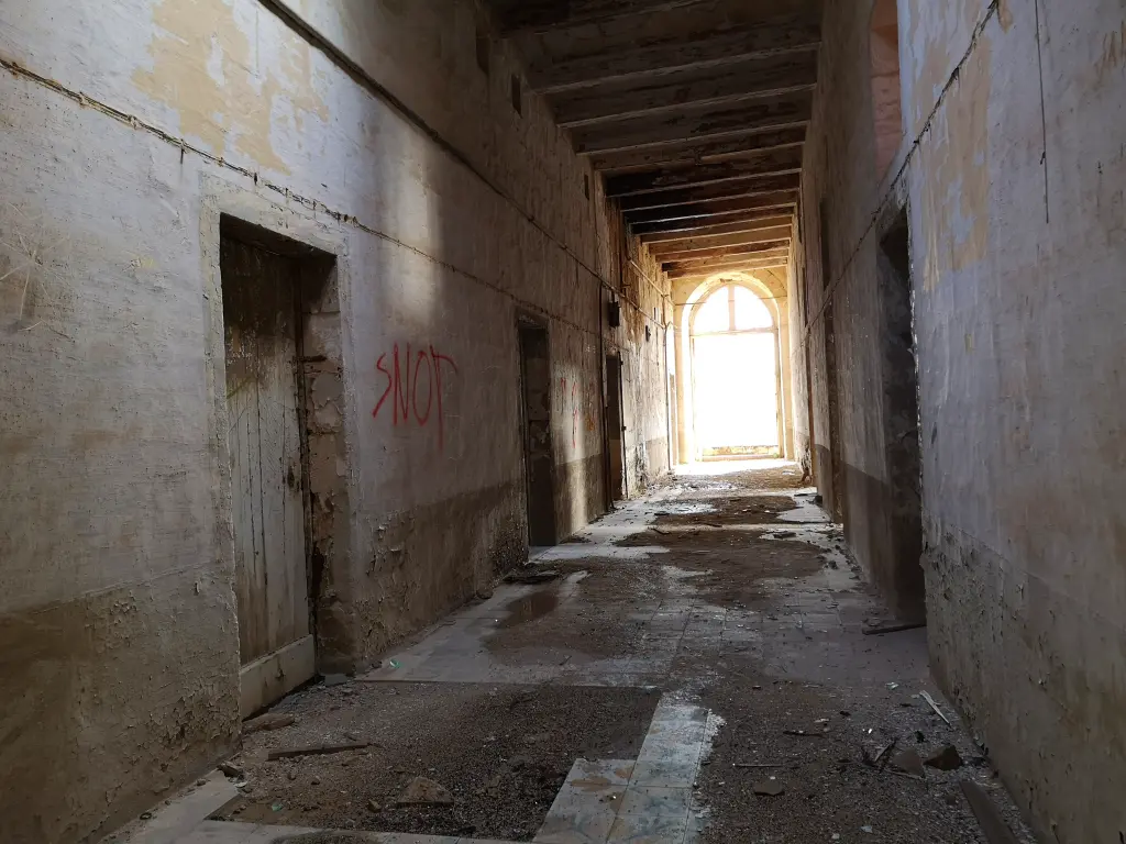Largo pasillo del Palacio Viejo del Lazareto de Malta, con ventana al fondo