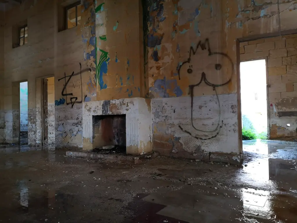 Sala de estar con chimenea en el Palacio Nuevo del Lazareto de Malta, destacando su arquitectura clásica