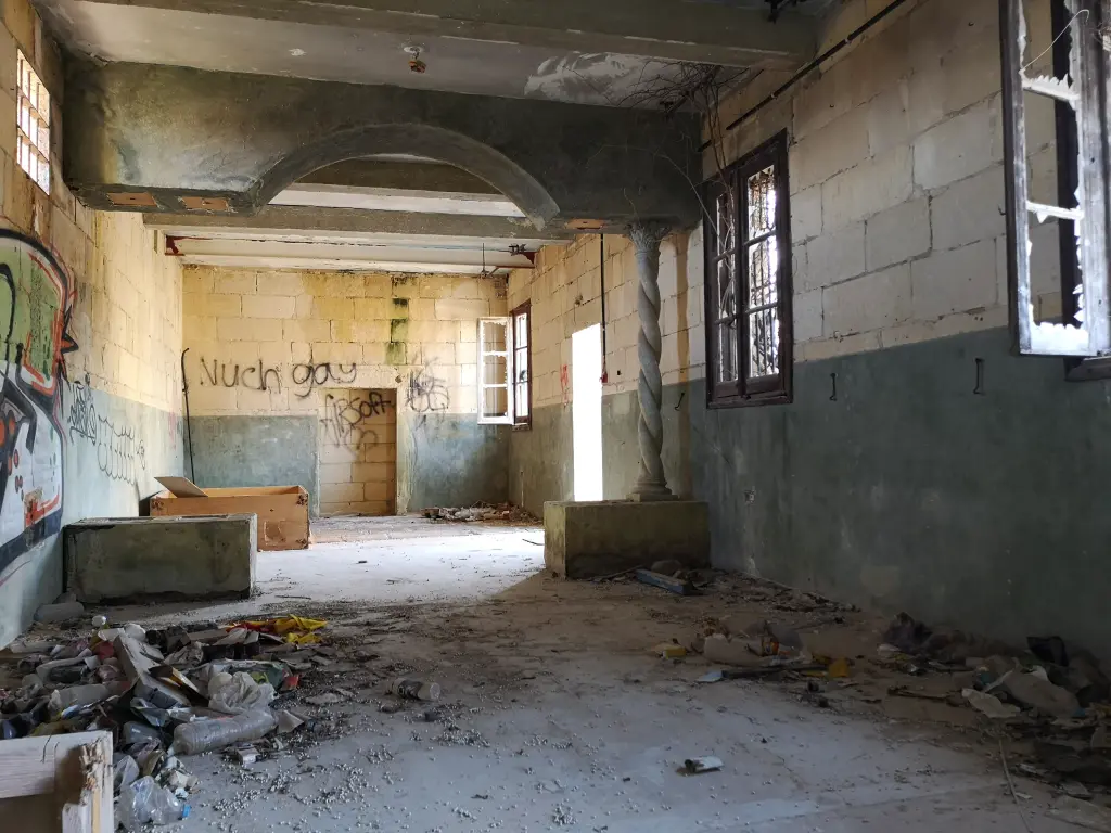 Sala en Rinella Movie Park, columna salomónica y escombros en el suelo.