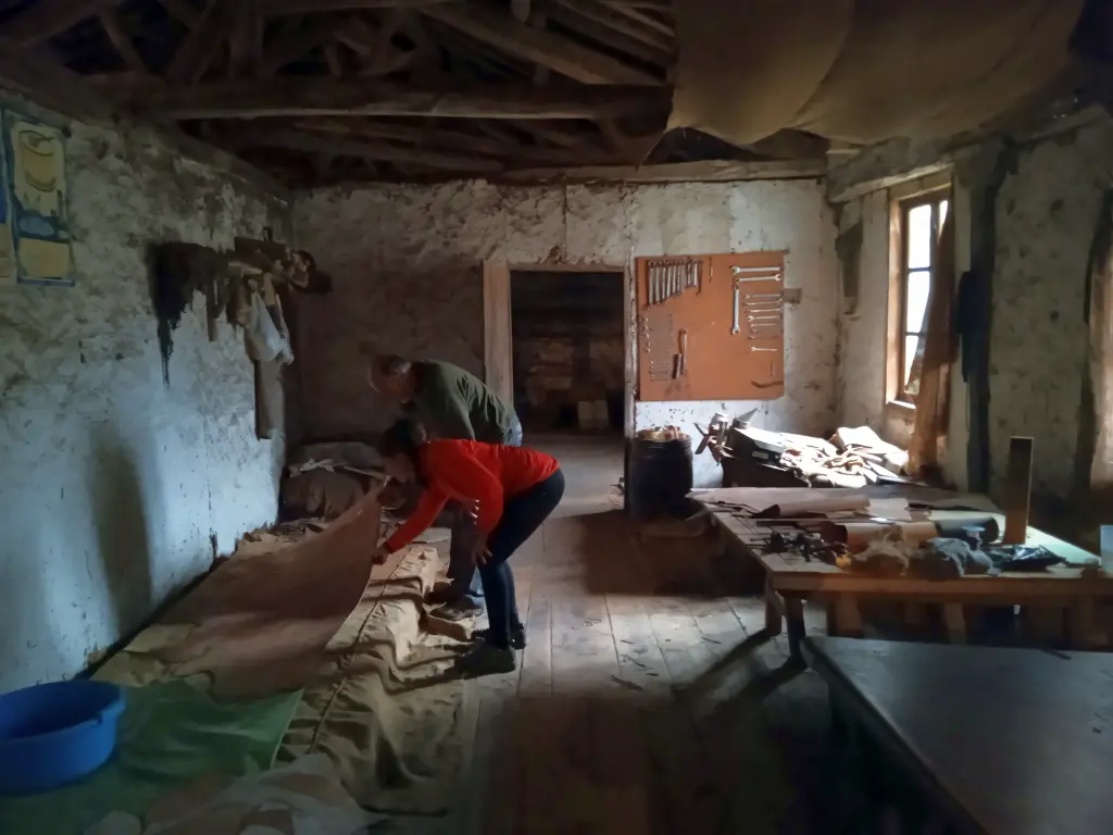 Una mujer eligiendo unas pieles en el antiguo taller de un curtidor.