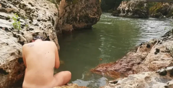 Joven mujer lavándose el pelo sin champú a orilla del Río Sella