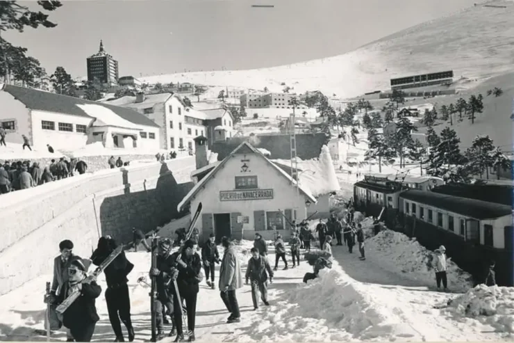Estación del tren del Puerto de Navacerrada, invierno de 1963. Visitantes salen de la estación con el equipo de esquiar.