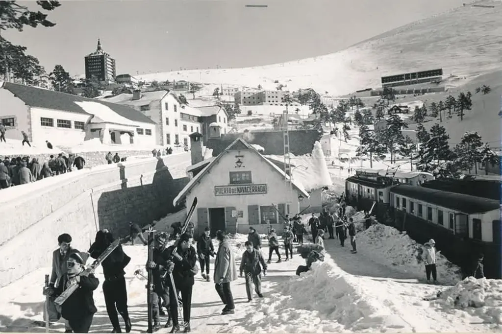 Estación del tren del Puerto de Navacerrada, invierno de 1963. Visitantes salen de la estación con el equipo de esquiar.