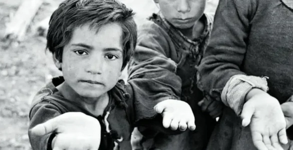 Primer plano de un niño y una niña con la mano tendida pidiendo. Foto tomada en Sanabria por Carlos Saura