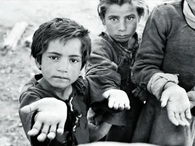 Primer plano de un niño y una niña con la mano tendida pidiendo. Foto tomada en Sanabria por Carlos Saura
