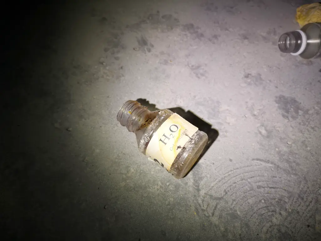 Un bote abierto de H2O en el suelo del sótano de la Piscina de Pesués