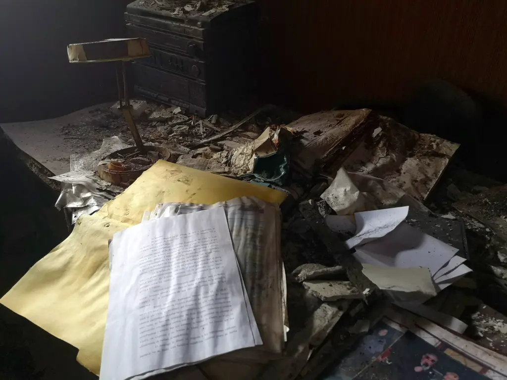 Escritorio repleto de documentos medio quemados del despacho de la abandonada sede de Falange de los Corrales de Buelna