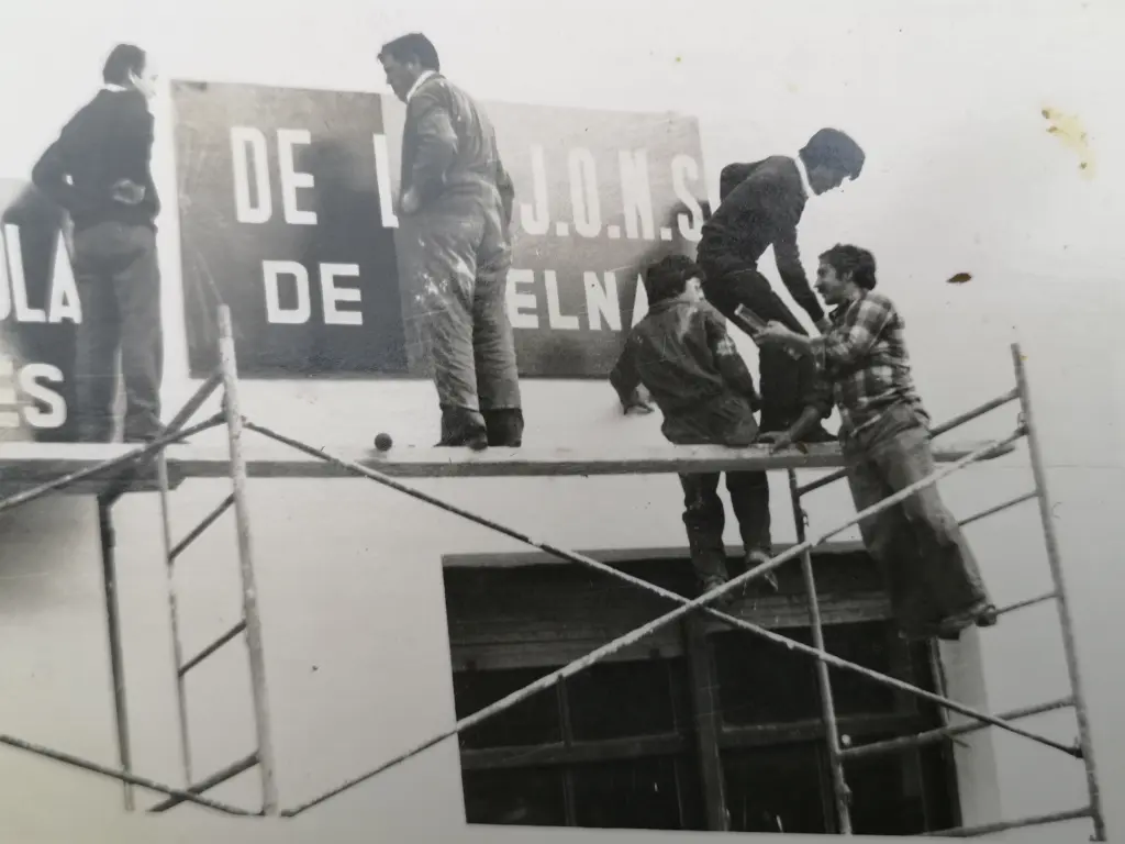 Foto en blanco y negro del 1977. Falangista pintando su sede de los Corrales de Buelna