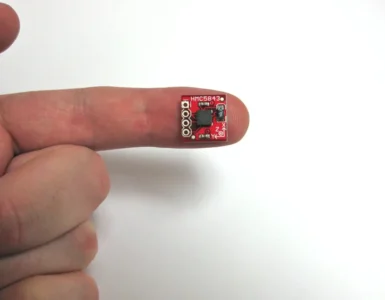 Dedo de una mano sobre fondo blanco sosteniendo un chip magnético