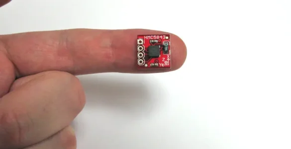 Dedo de una mano sobre fondo blanco sosteniendo un chip magnético