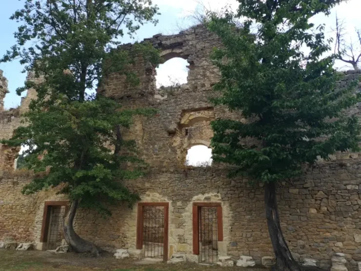 Fachada de la hospedería del Monasterio de Rioseco. Dos grandes árboles están a los dos lados de la entrada