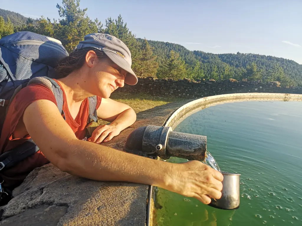 Chica recogiendo agua de un deposito para incendios forestales