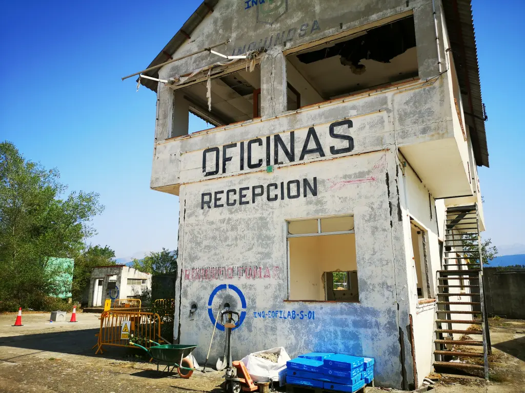 Foto exterior de las oficinas de la fñabrica abandonada de inquinosa, con rotulación y escalera