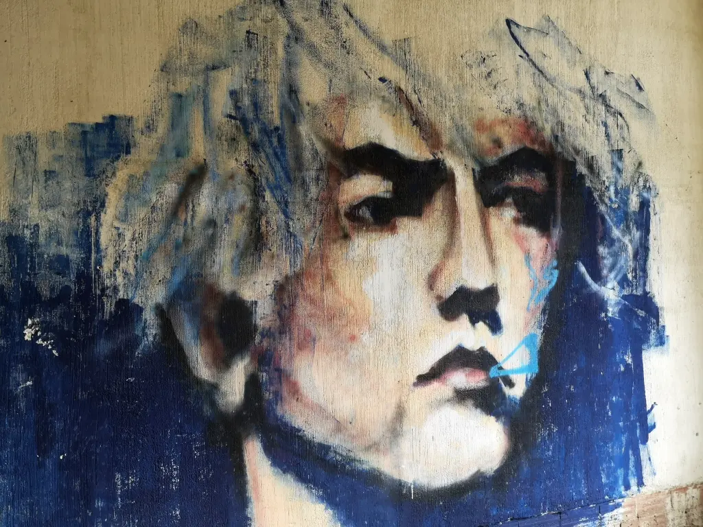 Graffiti en el sanatorio abandonado de Tablada: rostro masculino de perfil sobre fondo azul, mirando hacia el horizonte