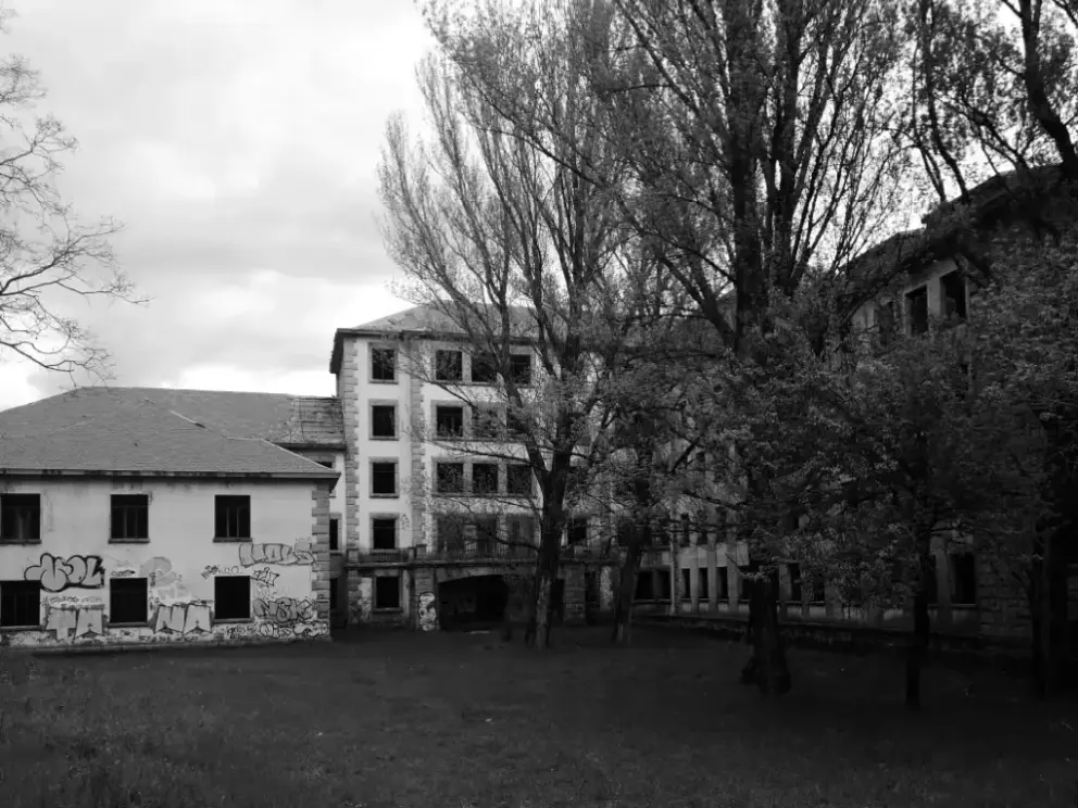 Vista en blanco y negro del sanatorio de Tablada: edificio principal entre árboles y dos secundarios a la izquierda
