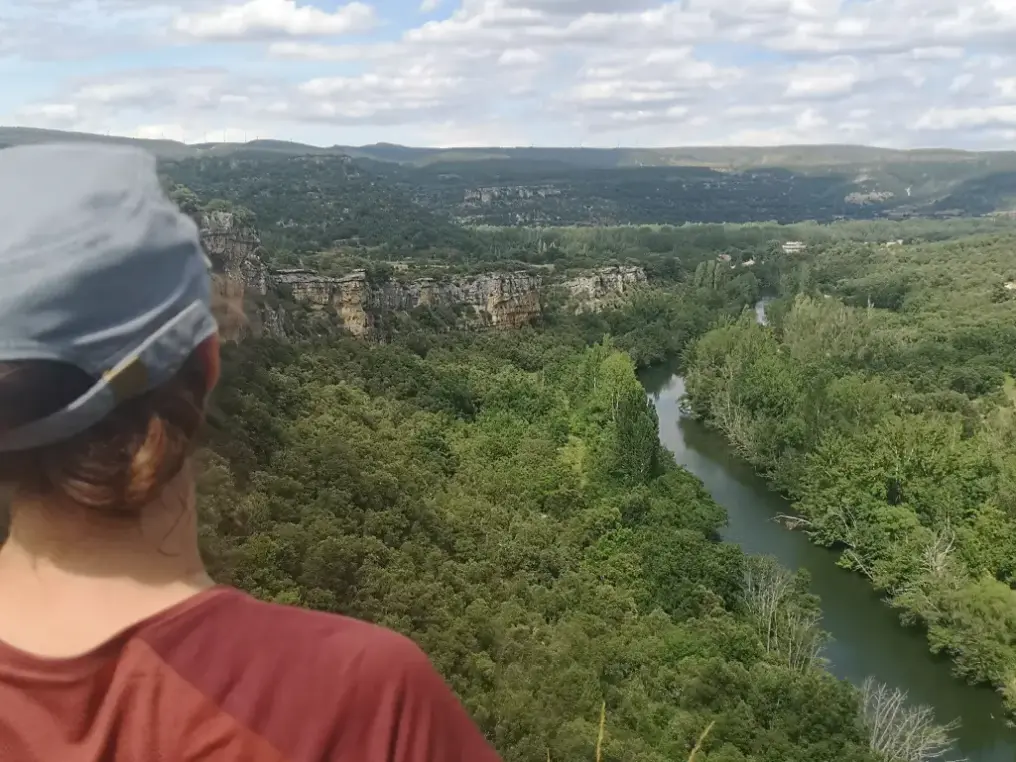 Viajera de espalda mira desde arriba un río inaccesible por estar encajonado en una garganta
