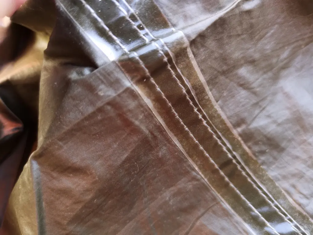 Detalle de una costura termosellada sobre el suelo de una tienda de campaña impermeabilizado con poliuretano