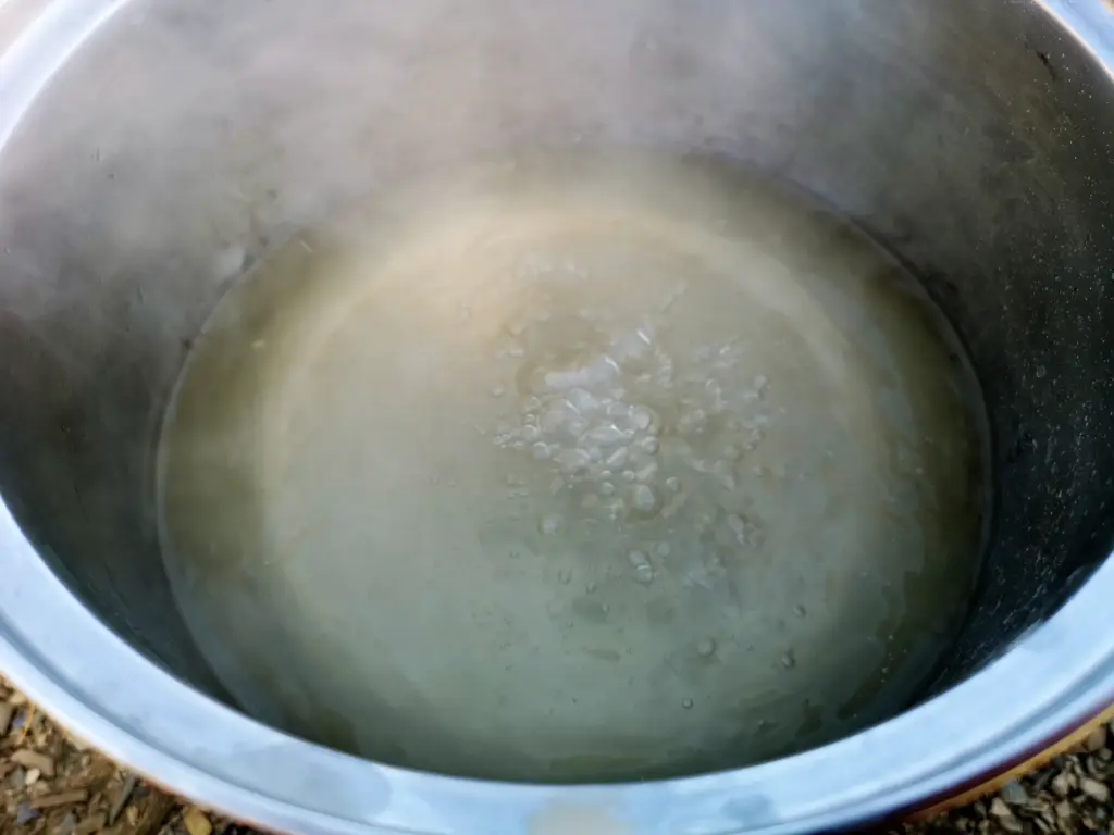 Primer plano de agua ligeramente turbia hirviendo en una olla para potabilizarla