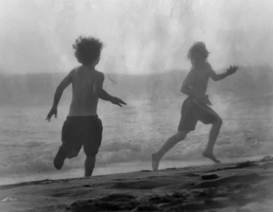 Pensamiento Nómada: Niños jugando a pilla pilla en la orilla del mar, representando la acción, el movimiento y la experiencia libre del conocimiento