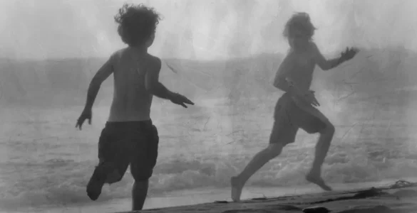 Pensamiento Nómada: Niños jugando a pilla pilla en la orilla del mar, representando la acción, el movimiento y la experiencia libre del conocimiento