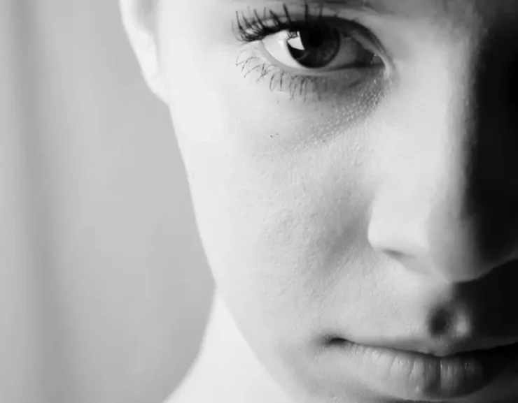 Primer plano monocromo de media cara de mujer con mirada intensa que simboliza la diferencia y el límite en el pensamiento