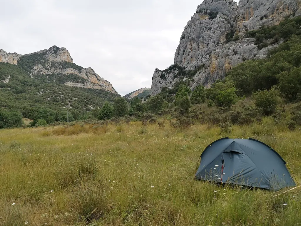 Tienda de campaña con revestimiento de silicona junto a la Senda del Ebro (GR 99) hacia Tudanca, rodeada de praderas y montañas
